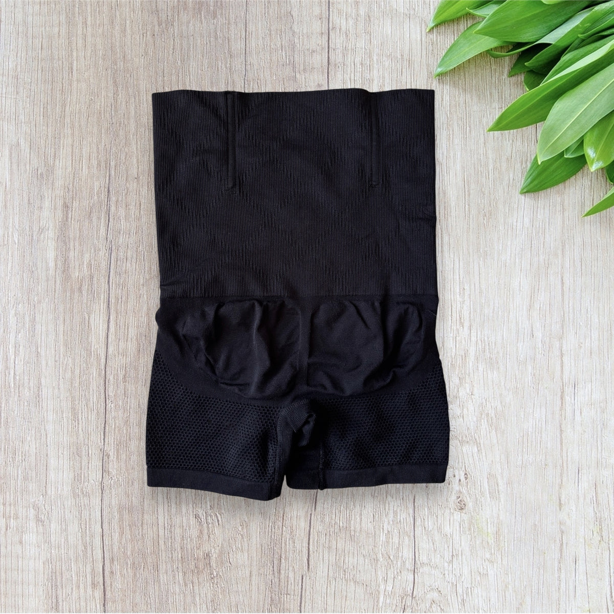 Gaine gainante femme noire taille haute avec coupe short et zones à texture ajourée.