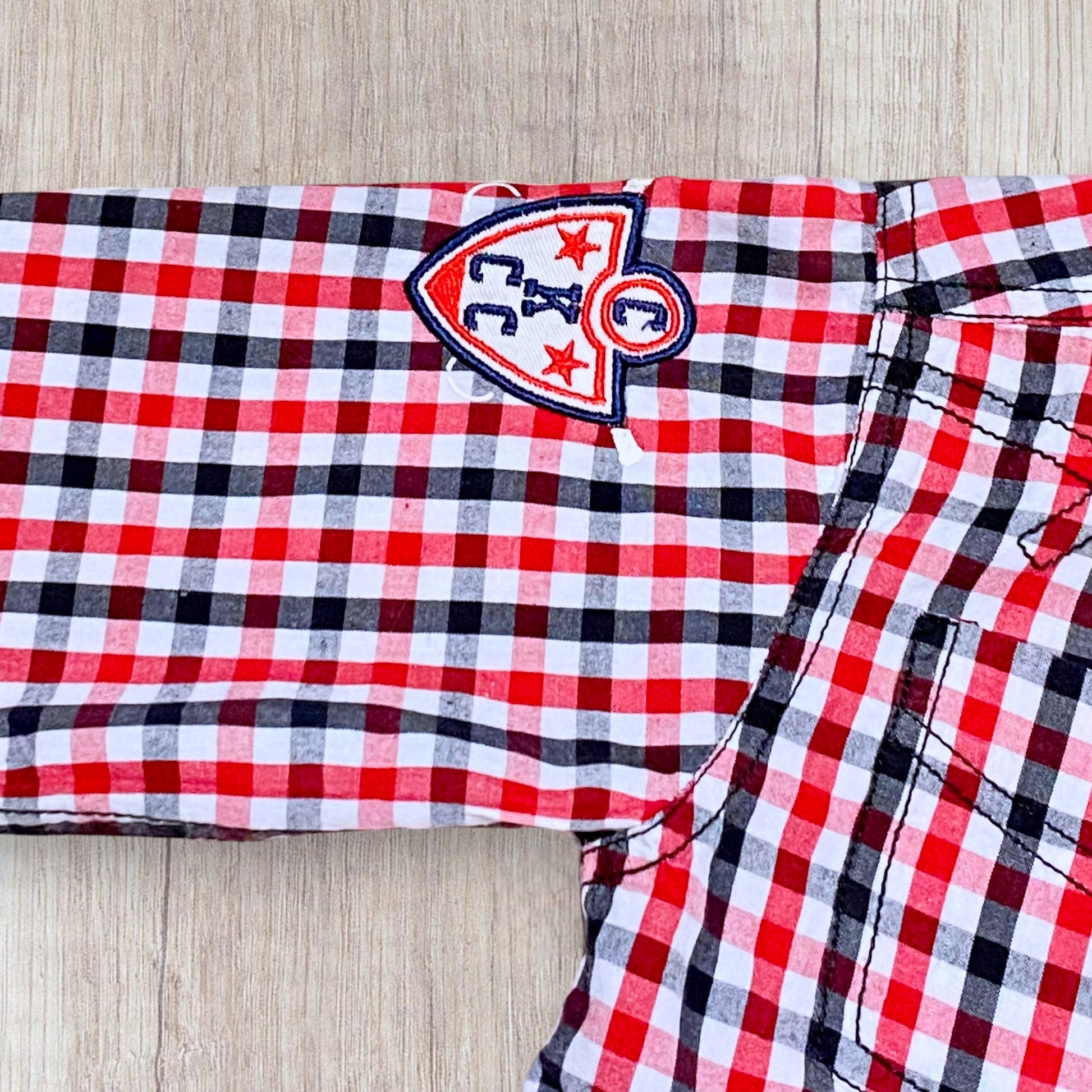 Chemise garçon P’tites Canailles 7 ans à carreaux rouge blanc noir avec broderie et boutons nacrés.