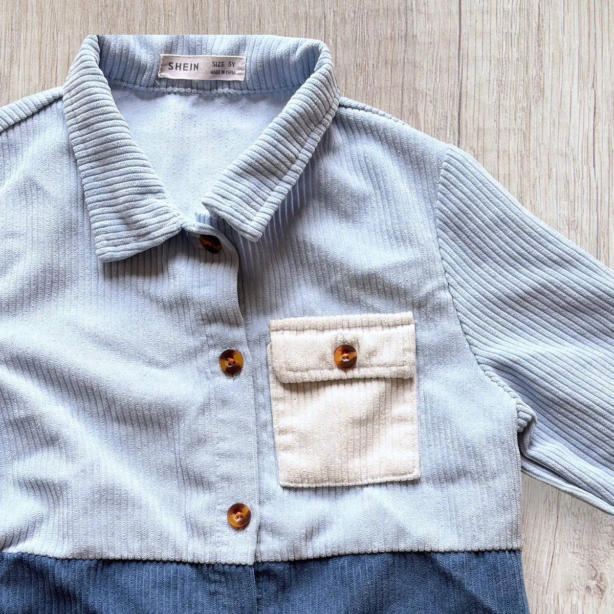 Chemise garçon Shein 5 ans en velours côtelé bleu ciel, bleu foncé et blanc avec boutons marron.