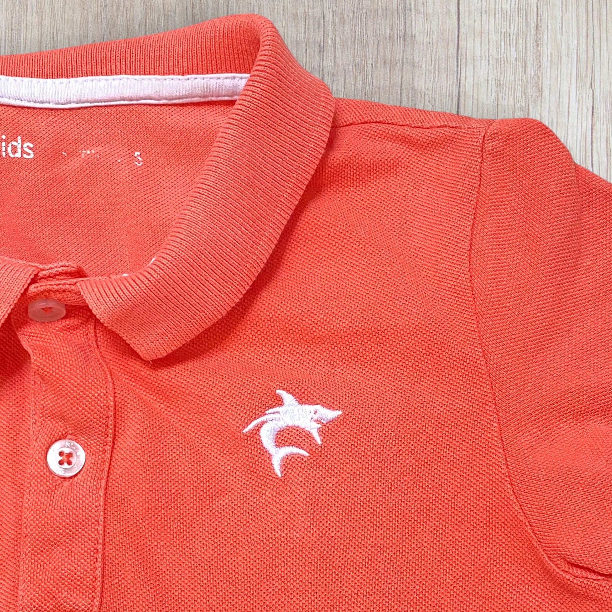 Polo garçon Gémo 5 ans – corail flashy – broderie requin – manches courtes – très bon état