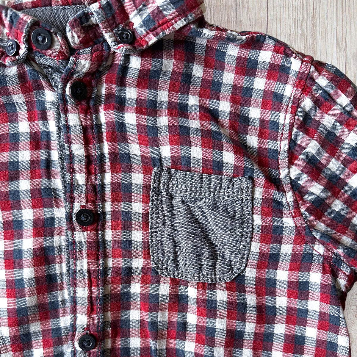 Ensemble garçon Kiabi 5 ans avec chemise à carreaux bordeaux, rouge, bleu marine et blanc, poche poitrine contrastante et pantalon en jean bleu.