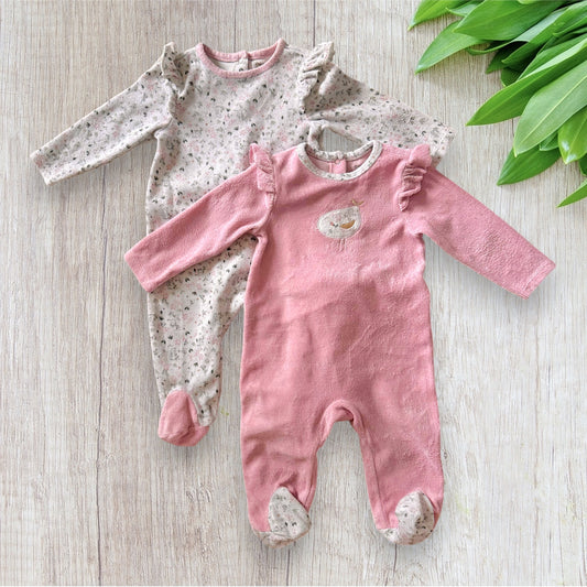 Lot de 2 pyjamas une pièce Orchestra pour bébé fille de 1 an, un modèle rose à motifs pingouins et un modèle blanc avec inscription rose et petits cœurs.