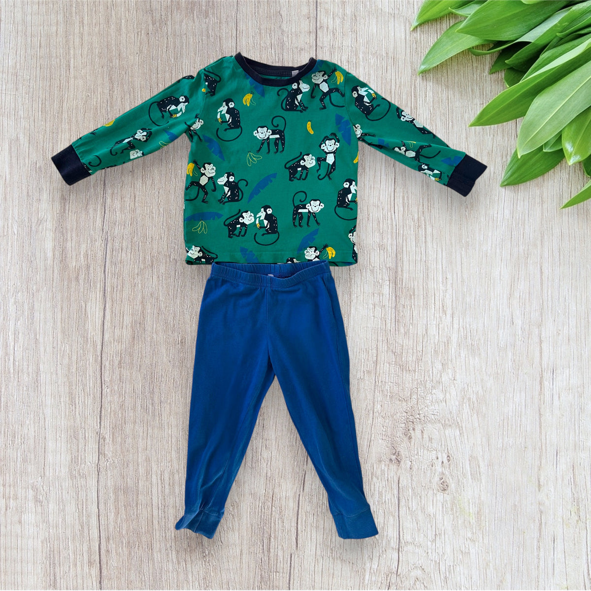 Lot de pyjama garçon C&A taille 2 ans composé d'un haut vert à motifs singes et bananes et de deux pantalons bleu marine et bleu.