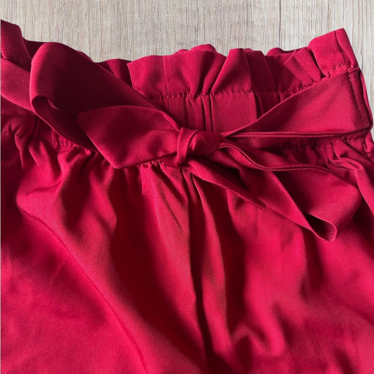 Ensemble fille Shein 8 ans avec haut blanc côtelé à boutons marron et pantalon rouge avec ceinture à nouer.