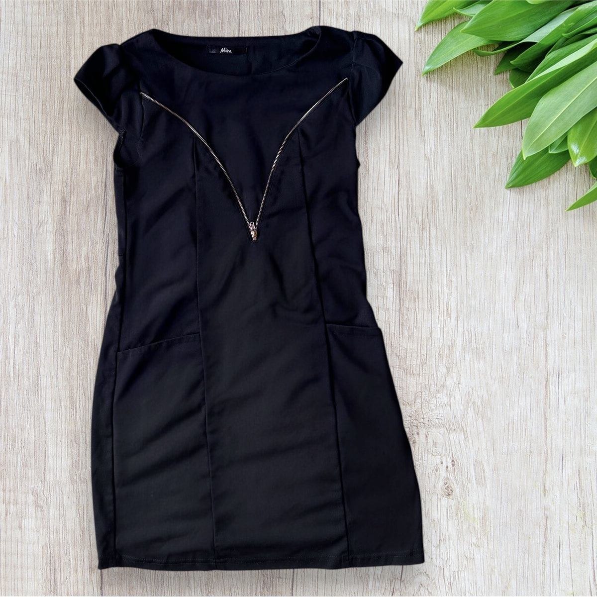 Robe courte femme MIM taille 36 noire avec motif graphique doré sur le devant, manches courtes et poches latérales.