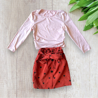 Ensemble fille Shein 8 ans composé d'un haut rose pâle à manches longues et d'une jupe terracotta effet velours côtelé à cœurs noirs.