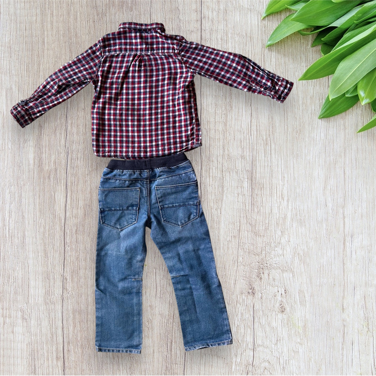 Ensemble garçon Kiabi 5 ans avec chemise à carreaux bordeaux, rouge, bleu marine et blanc, poche poitrine contrastante et pantalon en jean bleu.