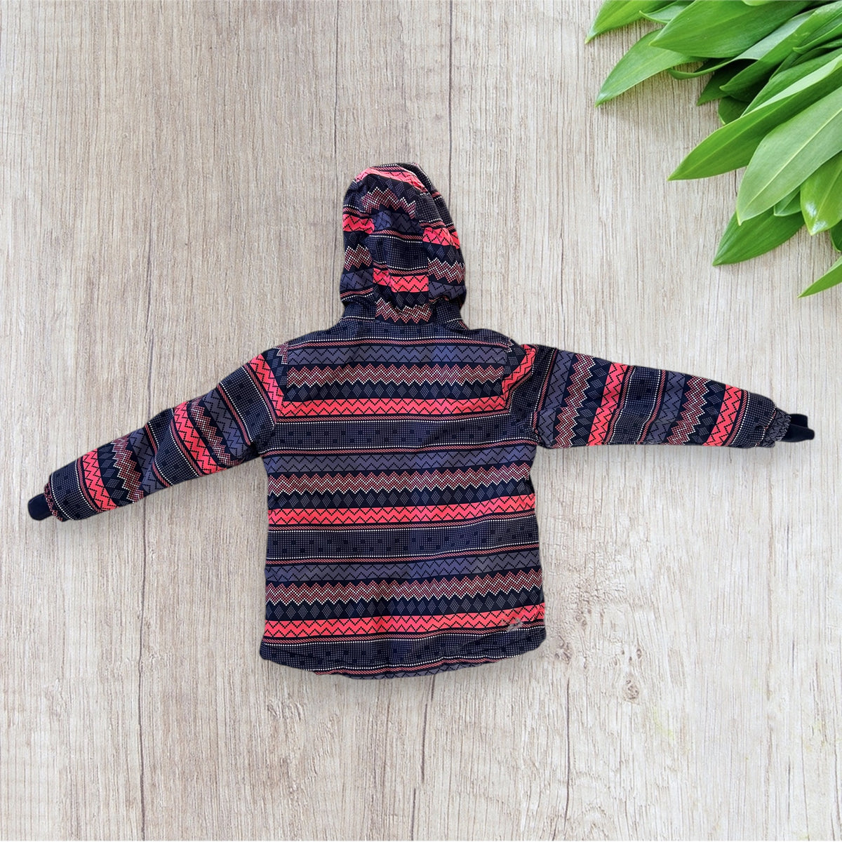 Veste de ski fille Crivit 7-8 ans bleu marine à motifs géométriques roses, blancs et violets, avec capuche, poches zippées et passe-pouces.